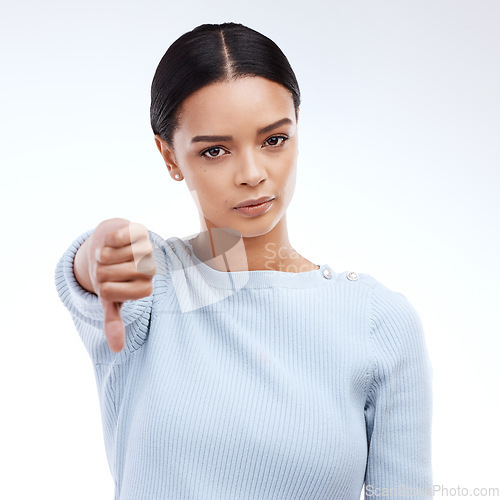 Image of Thumbs down, woman and portrait with problem and no opinion and choice in studio. Isolated, white background and bad review of young female feeling disappointed from vote and emoji of fail hand sign