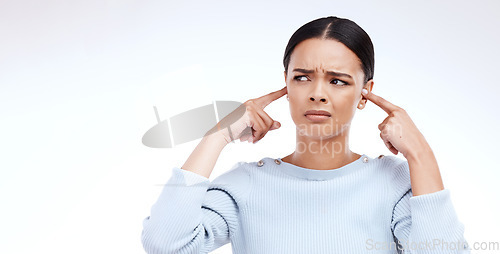 Image of Annoyed, woman and finger in ears for noise, loud and denial gesture on studio white background. Omg, face and angry girl with complaint, ignoring and deaf, wtf and emoji, frustrated and unhappy