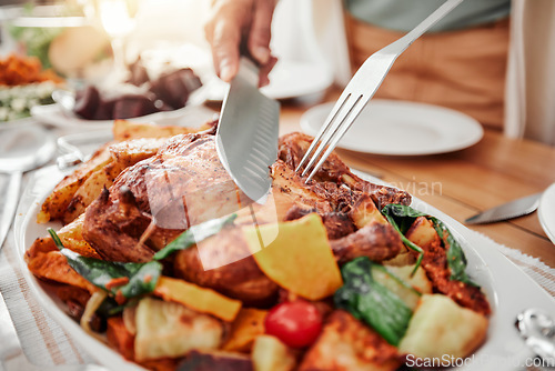 Image of Food, cutting roast chicken on tablet and dinner, party or celebration with Christmas or thanksgiving holiday. Social event, closeup and carve protein with knife, gourmet meal and festive feast