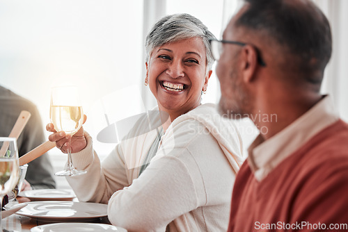 Image of Happy, smile and couple at lunch in family home, drinking wine and laughing at jokes. Conversation, together and a man and woman speaking with a drink during a dinner with friends in a house