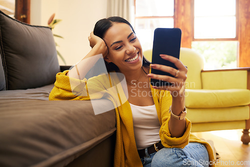 Image of Smile, relax and a woman with a phone for an app, communication and social media. Happy, funny and a girl reading a text message, chat or notification on a mobile in the living room of a house