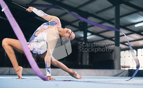 Image of Ribbon, gymnastics and flexible woman stretching in performance, dance training and sports competition. Female, rhythmic movement and dancing athlete for creative skill, talent and concert in arena