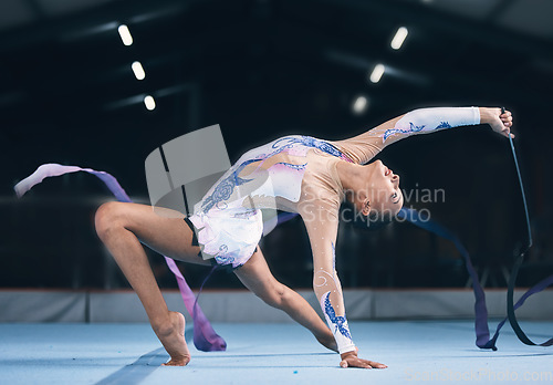 Image of Ribbon, gymnastics and flexible woman stretching in performance, dance training and sports competition. Female, rhythmic movement and dancing athlete, creative skill and talent for concert in arena