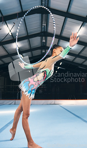 Image of Woman, gymnastics and hoop for performance, sports training and dancing action in arena. Female, rhythmic movement and dancer with spinning ring for creative talent, solo concert or balance challenge