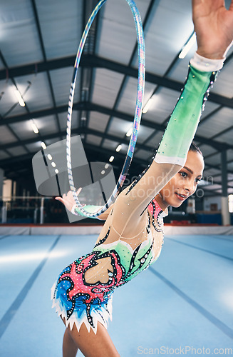 Image of Woman, gymnastics and hoop for competition, sports training and dancing action in arena. Female, rhythmic movement and dancer with spinning ring for creative talent, solo concert or event performance