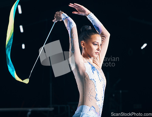 Image of Ribbon gymnastics, woman and dancer competition in talent show, performance and dark arena. Serious female athlete, rhythmic movement and dancing for solo action, creative sports and concert training