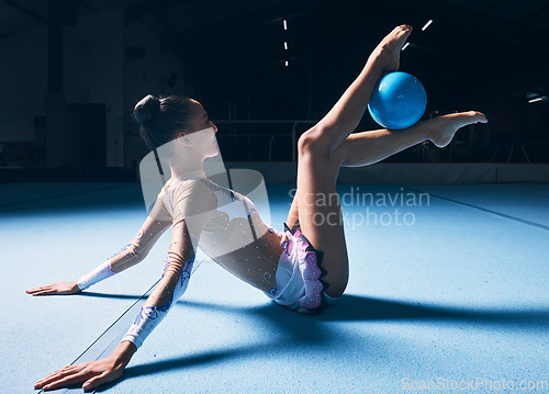Image of Woman, gymnastics and legs with ball for dancer performance, competition training or dark sports arena. Female athlete, rhythmic movement and creative talent in solo concert, agility skill or balance