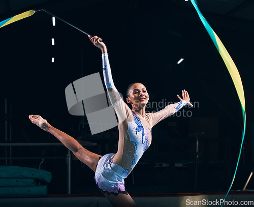 Image of Ribbon gymnastics, woman and happy portrait of dancer in performance, sports competition and dark arena. Female athlete, rhythmic movement and action of creative talent, dancing concert and balance