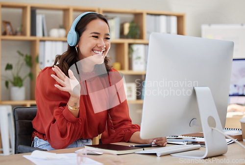 Image of Headphones, computer and woman video call, webinar or virtual meeting, talking and online networking in business office. Happy Asian person wave hello on her desktop pc in client chat at tech company