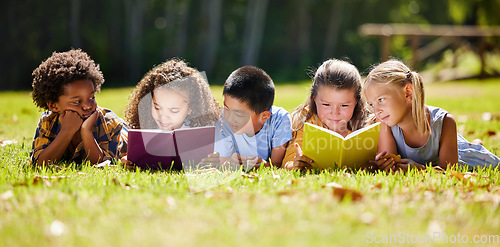 Image of Children, books and lying in park with friends, learning or diversity for reading at school playground. Kids, education or study with support, mockup space or solidarity at multicultural kindergarten