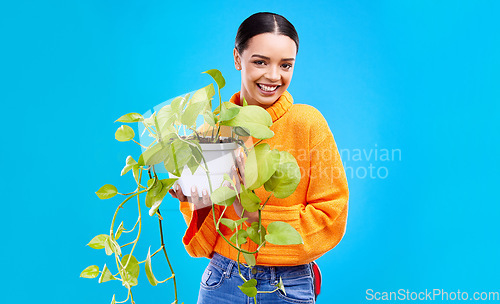 Image of Portrait of woman in studio with plant, smile and happiness with house plants on blue background. Gardening, sustainable green hobby and happy gen z girl in mockup space for eco friendly garden shop.