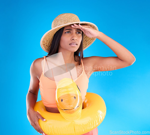 Image of Studio, shocked woman on beach and vacation on blue background, looking or search with hat and hand on face. Travel, pool holiday and worried girl with inflatable rubber duck, ocean wear on holiday.