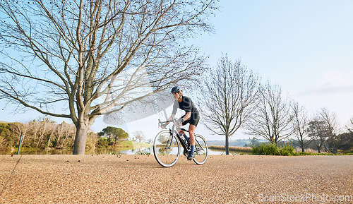 Image of Sports, bicycle and woman cycling in a forest for fitness, exercise and morning cardio in nature. Training, bike and female enjoying workout in a park, freedom and energy, performance and endurance