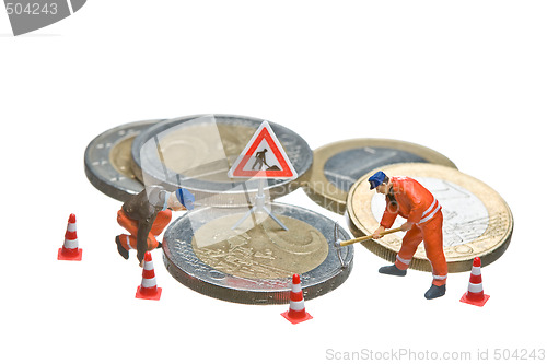 Image of Miniature figures working on a heap of Euro coins.