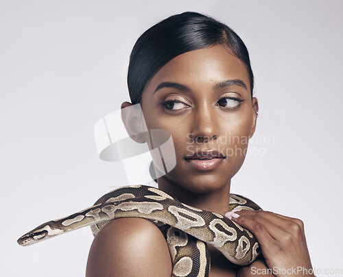 Image of Fashion, beauty and woman in studio with snake on neck for art aesthetic with exotic zoo animal on white background. Face, danger and creative style, asian model with seductive look and dangerous pet