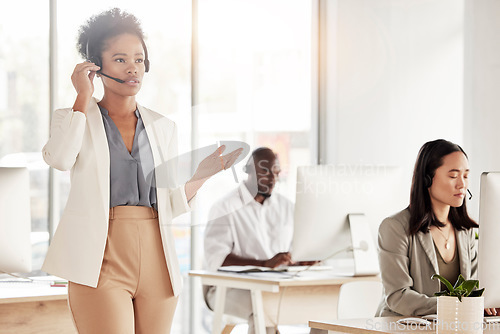 Image of Call center, black woman and business communication in office, coworking sales agency and customer service. Female telemarketing agent talking on headset for help, crm advisory and telecom support