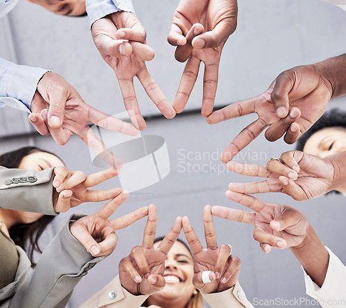 Image of Hands, star and together in low angle for business people with teamwork, motivation and solidarity in office. Women, happiness and peace sign with shape, team building and support for company goals