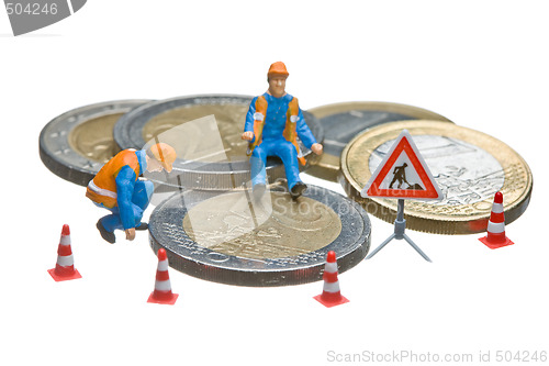 Image of Miniature figures working on a heap of Euro coins.