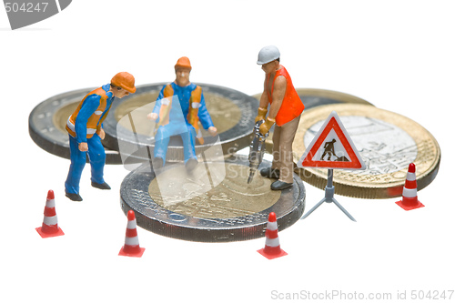 Image of Miniature figures working on a heap of Euro coins.