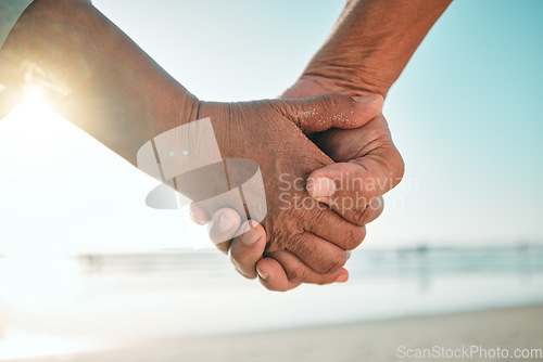 Image of Holding hands, beach and couple at sea or ocean during sunrise on holiday or vacation in nature with love and care. Closeup, travel and happy people in the morning together on a romantic date