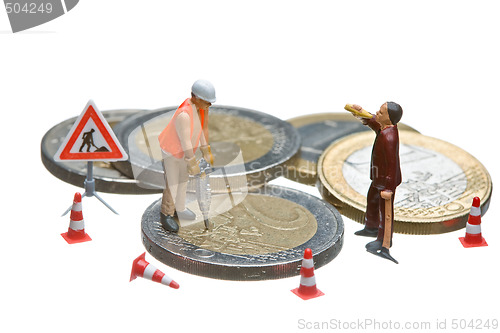 Image of Miniature figures working on a heap of Euro coins.