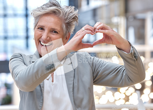 Image of Business, heart and hands with portrait of woman in office for support, kindness and target. Corporate, goal and happy with senior female and positive gesture for success, achievement and motivation