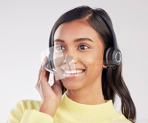 Image of Woman has smile on face, callcenter and headset with mic, CRM and contact us with consultant on studio background. Happy, Indian female with customer service agent and help desk with tech support