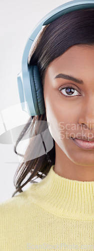 Image of Serious, half and portrait of a woman with headphones for music isolated on a white background. Cropped, young and an Indian girl listening to audio, streaming radio or podcast on a backdrop
