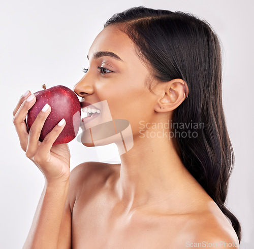 Image of Woman, apple with face profile and health with nutrition and fruit, healthy food and diet on studio background. Weight loss, organic and fresh produce with happy female eating, wellness and lifestyle