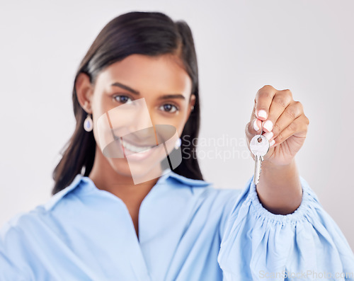 Image of Happy, showing and a portrait of a woman with keys isolated on a white background in a studio. Real estate, smile and a girl holding a key to a house, apartment or property as a new homeowner