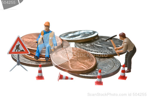 Image of Miniature figures working on a heap of Dollar coins.