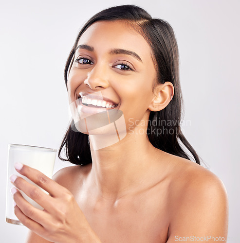 Image of Woman with smile in portrait, glass of milk and health with nutrition, vitamins and calcium on studio background. Organic, healthy lifestyle and wellness with happy female, diet and dairy product