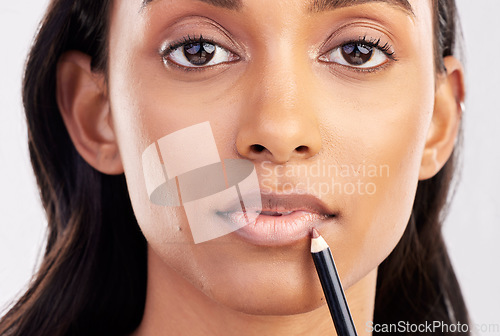 Image of Woman, face closeup and portrait with lip liner makeup, beauty and cosmetic product on studio background. Indian female, cosmetics pencil for lips and lipstick with healthy skin and cosmetology