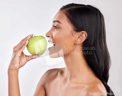 Image of Woman, apple and face profile, health nutrition and fruit with healthy food and detox diet on studio background. Weight loss, organic and fresh produce with happy female mouth, wellness and lifestyle