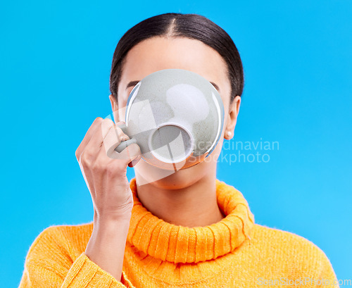 Image of Coffee drinking, woman and studio with morning latte, mug and hot beverage. Isolated, blue background and female model or young person with casual fashion and ceramic cup for tea drink or cappuccino