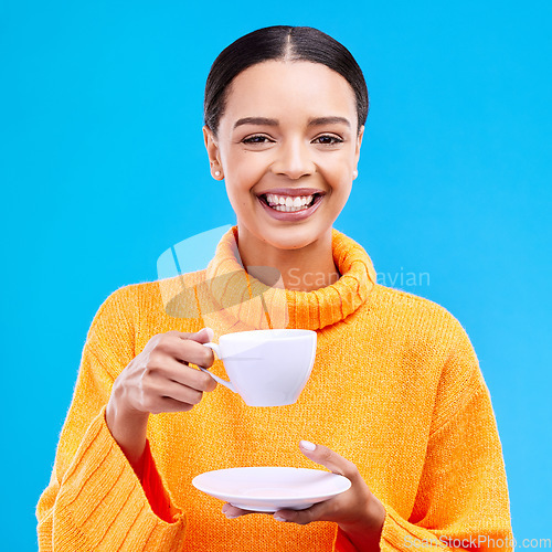 Image of Tea, woman portrait and smile in studio with happiness, latte or matcha mug. Isolated, blue background and happy female model or young person smiling with casual winter fashion, joy and coffee drink