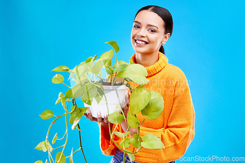 Image of Portrait of woman on blue background with plant, smile and happiness with house plants in studio. Gardening, sustainable and green hobby for happy gen z girl on mockup for eco friendly garden shop.