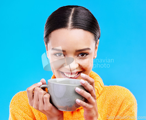 Image of Coffee, woman portrait and smile in studio with happiness and mug. Isolated, blue background and happy female model or young person with casual winter fashion, latte or tea drink with smiling joy