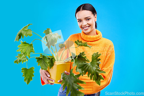 Image of Sustainability, portrait and happy woman in studio with plant, smile and house plants on blue background. Gardening, sustainable and green hobby for gen z girl on mock up and eco friendly backdrop.