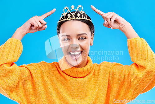 Image of Pointing, tiara or portrait of woman hands in studio celebration, princess or dress up party. Smile, beauty or fashion with female crown on blue background and excited for achievement, winner or prom