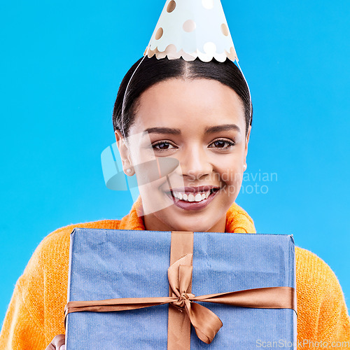 Image of Woman, birthday and box in studio portrait with smile, happiness and present by blue background. Girl, model and party with gift, hat and excited face for celebration, event and package by backdrop