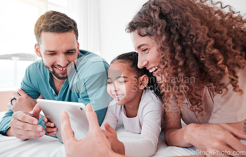 Image of Happy, bed and family with a tablet, comic and connection for social media, funny videos or quality time. Parents, mother and father with daughter, bedroom and female child with device or interracial