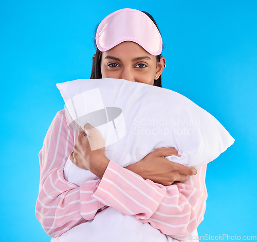Image of Portrait, pillow and woman in pajamas, happy and ready for sleeping against isolated blue studio background. Face, female and person with sleepwear, eye mask and calm with happiness and cushion hug