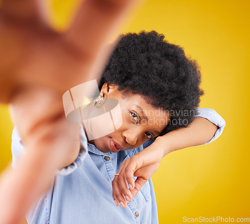 Image of Hand, selfie and black woman in studio for fashion, creative and pose against a yellow background. Face, serious and African female influencer posing for profile picture, photo or web post isolated