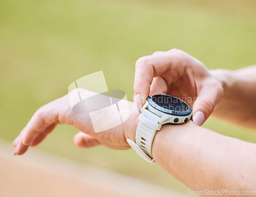 Image of Hands, exercise and smart watch with a sports person outdoor, checking the time during a workout. Arm, fitness and technology with an athlete tracking cardio or endurance performance while training