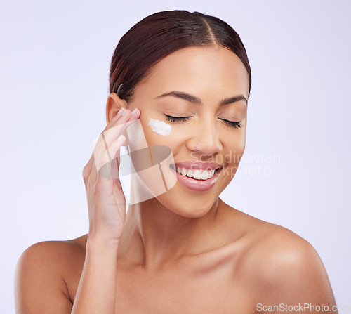 Image of Face cream, skincare and woman in studio for cosmetic, treatment and dermatology on purple background. Facial, lotion and sunscreen for happy lady model relax with spf, moisturiser or beauty routine