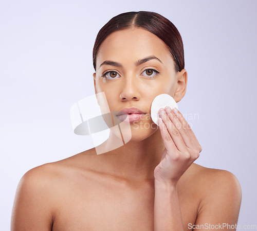 Image of Portrait, skincare and cotton pad with a woman in studio on a gray background for natural treatment or beauty. Facial, wellness and anti aging with an attractive young female exfoliating her face