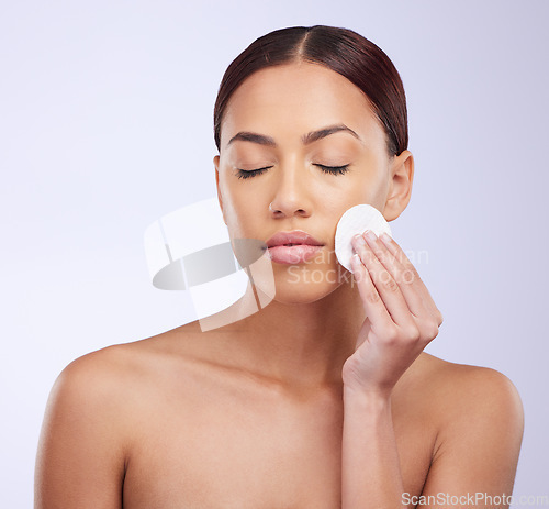 Image of Beauty, skincare and cotton pad with a woman in studio on a gray background for natural treatment. Facial, wellness and anti aging with an attractive young female exfoliating her face or skin