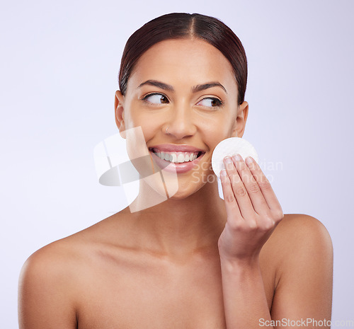 Image of Smile, beauty and cotton pad with a woman in studio on a gray background for natural treatment or skincare. Facial, wellness and happy with an attractive young female exfoliating her face or skin