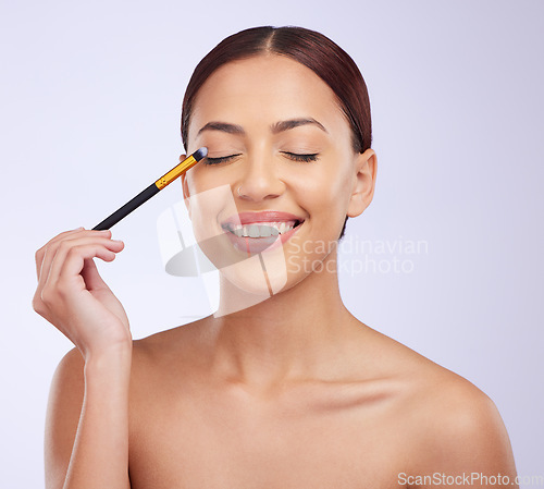 Image of Makeup, skincare or happy woman with eye pencil cosmetics facial beauty or wellness routine in studio. Smile, model or Brazilian girl applying foundation products or cosmetics with mockup space